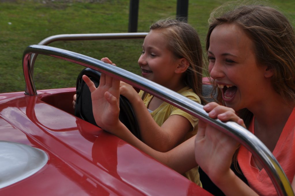 People riding in classic cars.