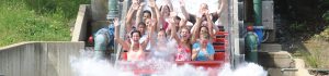 People on a log flume with their hands in the air.