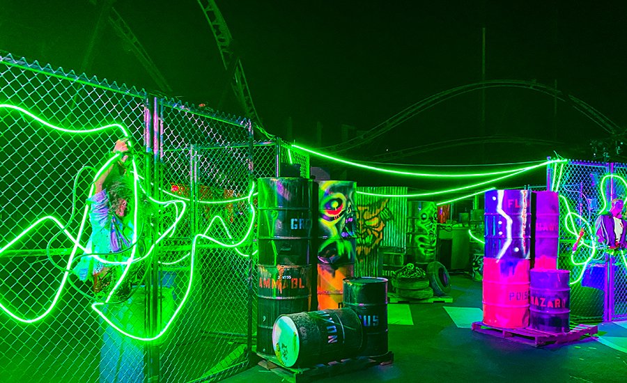green neon lights with glowing barrels in Deadzone at Six Flags Magic Mountain