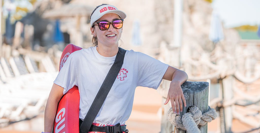 a lifeguard smiling and wearing sunglasses at six flags