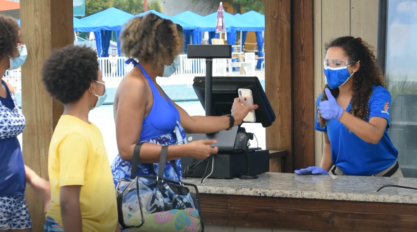 Employee at Hurricane Harbor checking out guests shopping